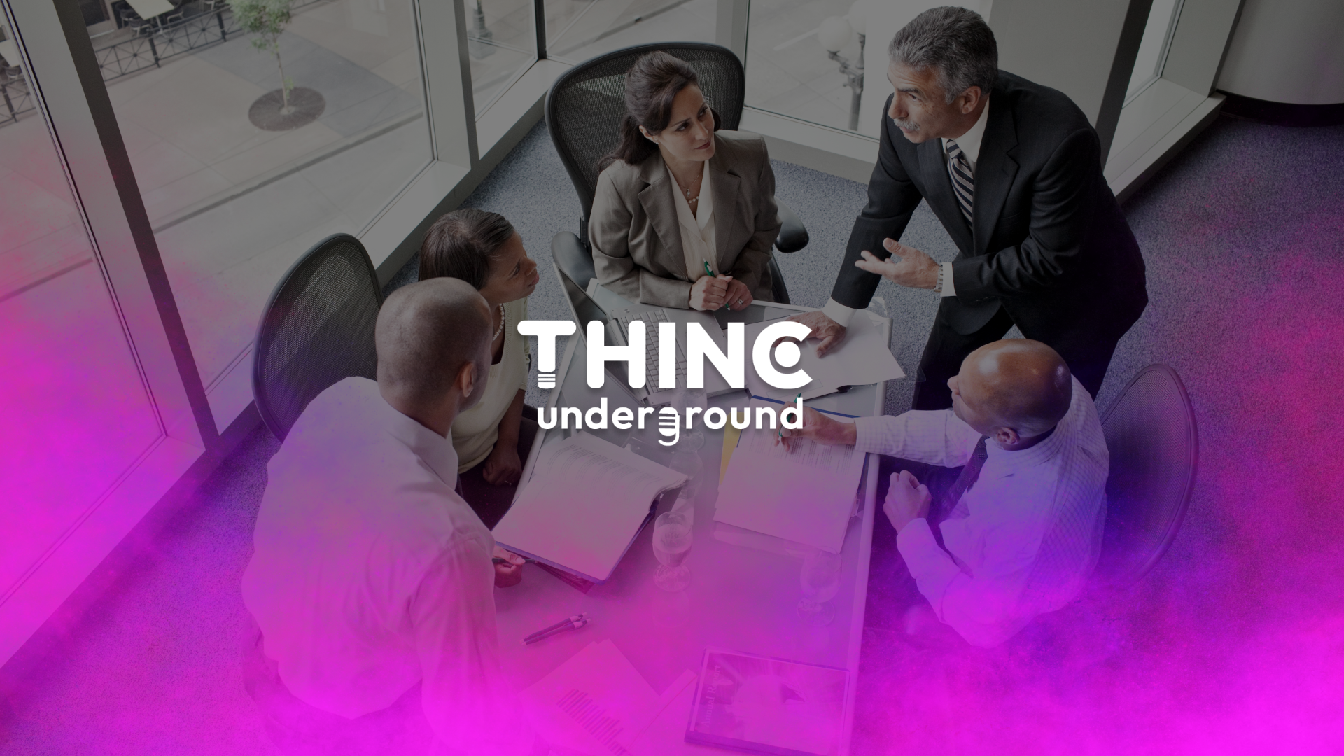 5 professionals gathered around a board room table